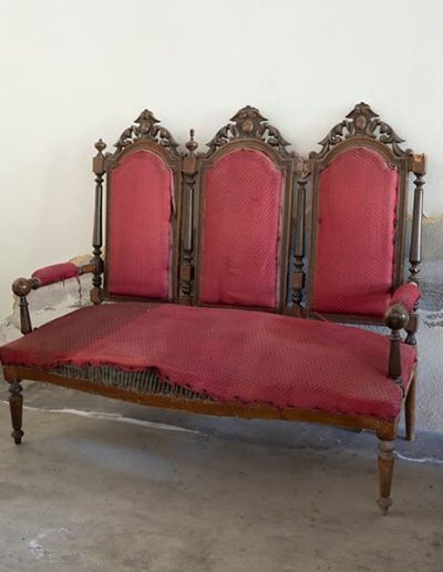 Egurrezko sofa, gorriz tapizatuta, XIX. gizaldiaren amaierakoa.