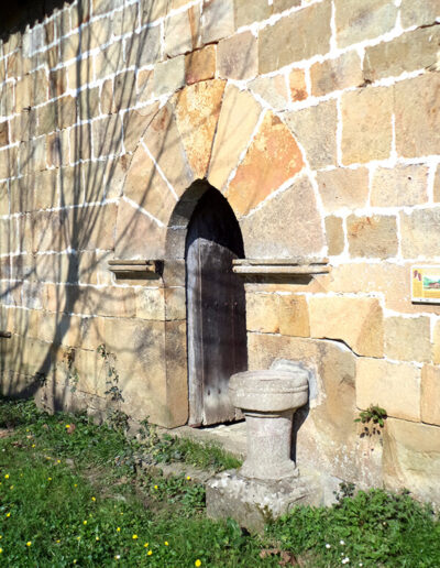 Junto a la puerta del lado sur se dispone la antigua pila bautismal de la ermita.