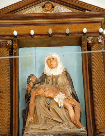 Imagen tardogótica de la Piedad que remata el retablo.