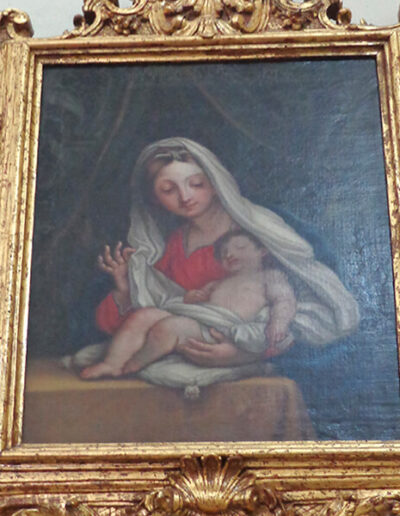 Pintura con la imagen de la Virgen con el Niño con un interesante marco rococó.